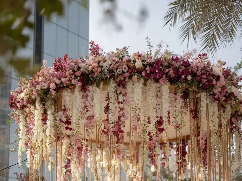 Round floral canopy of pink, red and white flowers with white wisteria hanging below