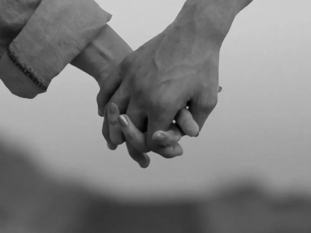 Two hands clasped together in black and white