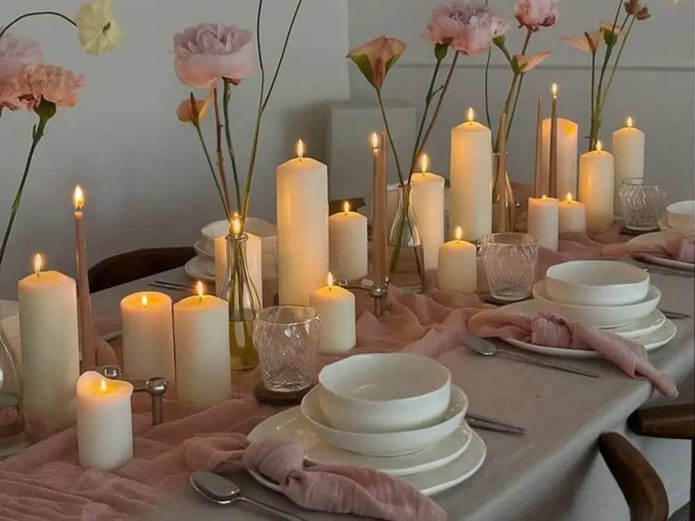 Pale pink table runner with pillar candles, bowls and single stem flowers