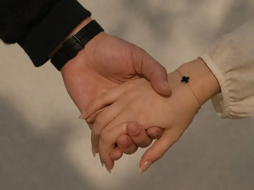 Two hands held together against a soft grey background