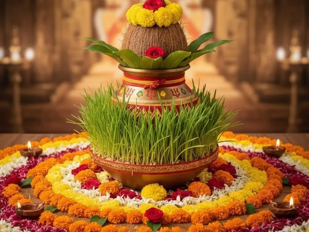 Brass kalash with coconut and mango leaves on a marigold and petal rangoli