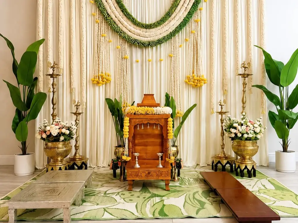Janeu ceremony setup with ivory drapes, brass lamps, white flowers and a wooden seat
