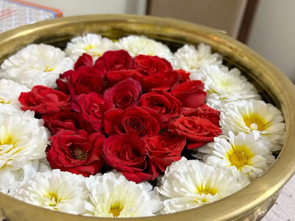 Brass bowl of red roses ringed with white chrysanthemums