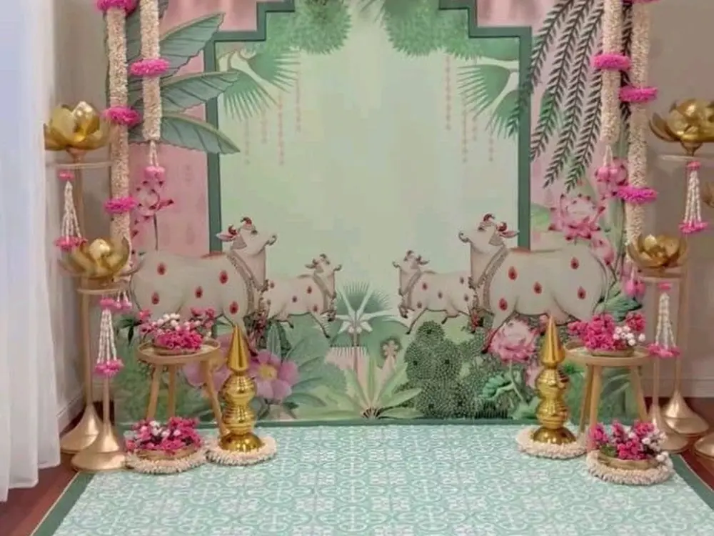 Mint green mundan backdrop with brass lamps, marigold strings and pink flowers