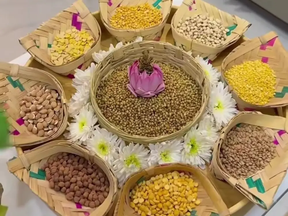 Navagraha puja platter of nine grains in leaf bowls with white chrysanthemums