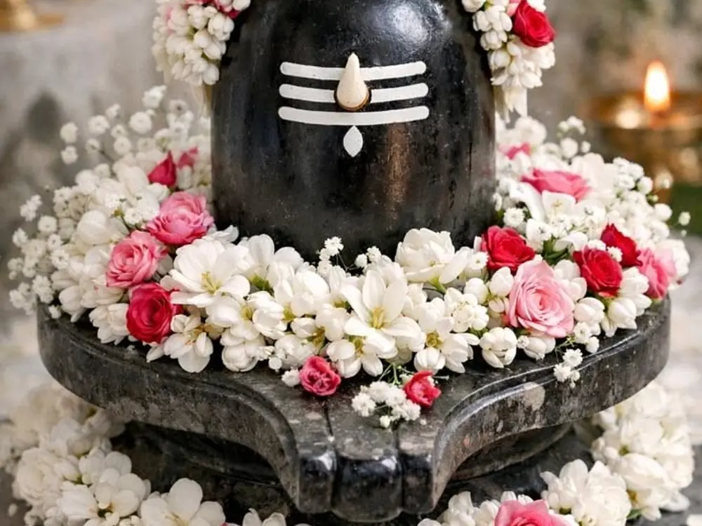 Shivling covered in a ring of white jasmine, pink roses and gypsophila
