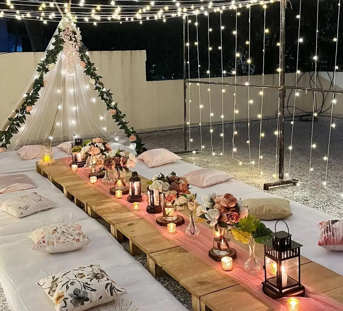 Outdoor cafe table decorated with string lights for an evening celebration