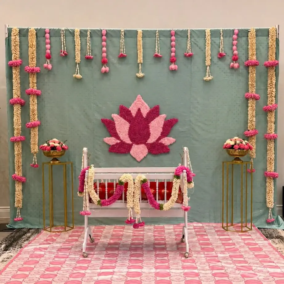 A pastel stage with a lotus motif, flower strings and a cradle seat, shown as inspiration