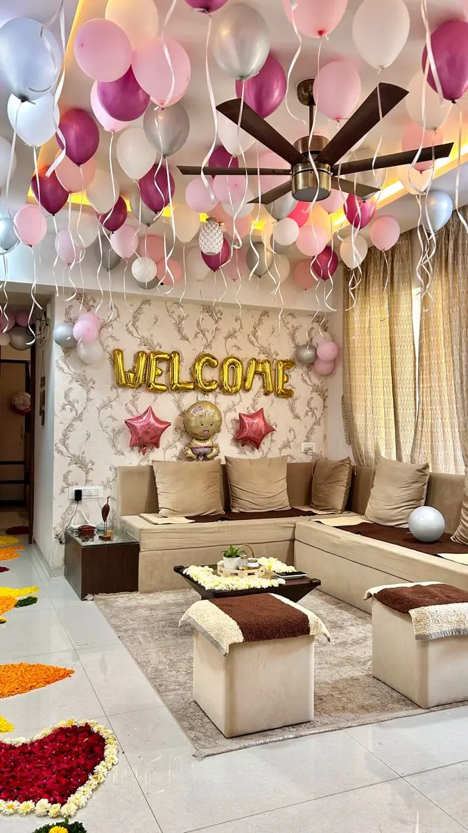 A living room with pink balloons on the ceiling and a Welcome sign