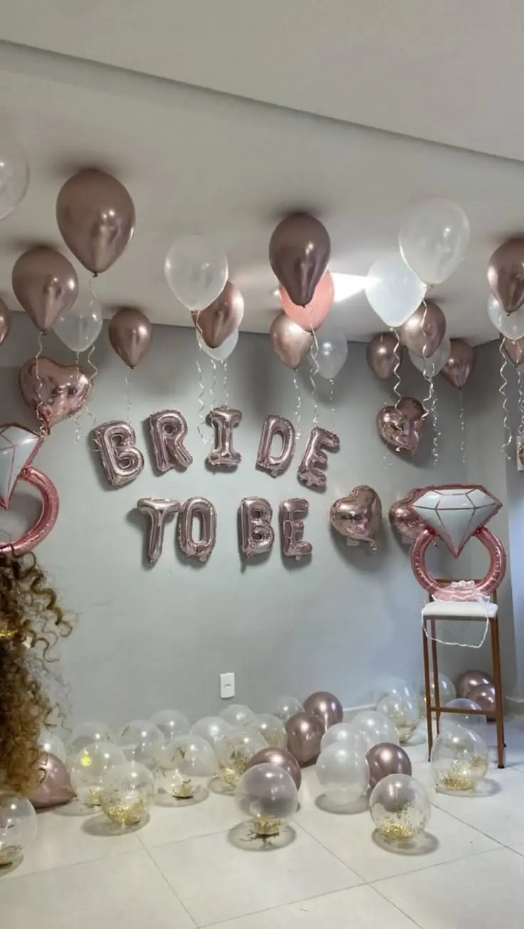 Bride To Be foil letters on a wall over white and silver balloons