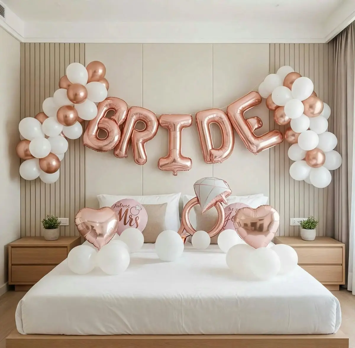Rose gold BRIDE foil letters over a white bed with heart balloons