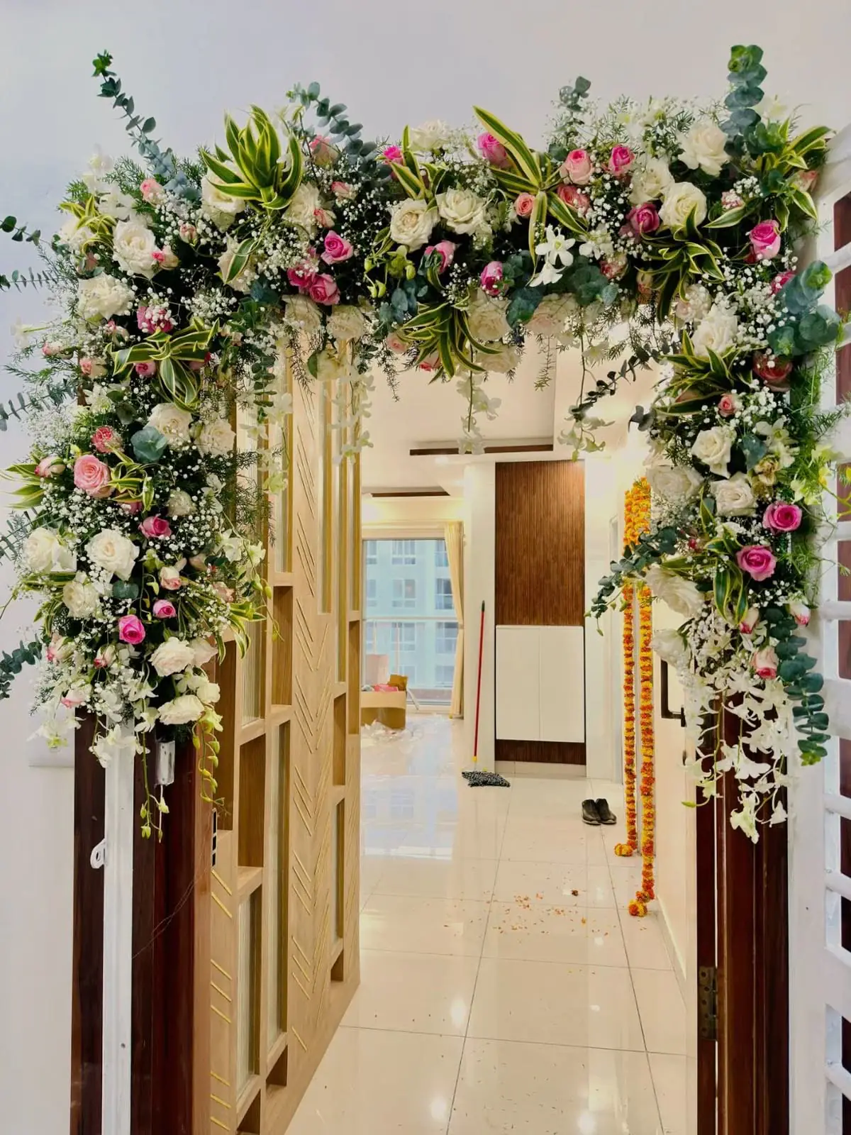 A flower arch of white, pink and green blooms framing an entrance, shown as inspiration